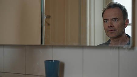 Мужчина смотрит в зеркало